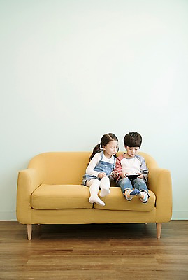 포토 JPG 전신 응시 여자 남자 어린이 실내 남매 앉기 두명 앞모습 스마트폰 소파 한국인 어린이만 국내포토 시선 뷰포인트 의자 가족 모션 사람 동양인 내부 핸드폰 스마트기기 파일형식