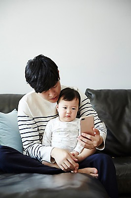 포토 JPG 응시 남자 아들 거실 가족 안기 실내 들기 앉기 상반신 성인 두명 앞모습 30대 스마트폰 소파 한국인 육아 아기 가족라이프 찡그림 아빠 화상통화 부자지간 남자만 남성육아휴직 육아대디 싱글대디 한부모가족 국내포토 라이프스타일 시선 뷰포인트 의자 관계 모션 표정 사람 동양인 내부 장년 핸드폰 스마트기기 통화 파일형식 육아휴직