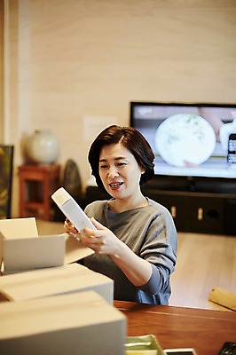 포토 JPG 응시 여자 중년 50대 거실 중년라이프 실내 한명 미소 앉기 상반신 앞모습 아웃포커스 소파 텔레비전 한국인 택배 택배상자 중년여자한명만 국내포토 1 라이프스타일 시선 뷰포인트 의자 모션 촬영기법 표정 사람 동양인 성인 내부 전자제품 상자 운송업 여자한명만 중년여자만 파일형식