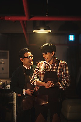 포토 JPG 남자 40대 중년 전등 실내 웃음 사람 상반신 20대 성인 두명 앞모습 앞치마 한국인 작업실 스승 제자 남자만 가죽공방 국내포토 뷰포인트 조명 표정 동양인 청년 내부 공예 파일형식