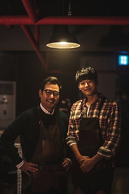 포토 JPG 남자 40대 중년 전등 실내 서기 미소 사람 상반신 20대 성인 두명 앞모습 앞치마 한국인 작업실 고수 스승 제자 남자만 가죽공방 국내포토 뷰포인트 모션 조명 표정 동양인 청년 내부 공예 향신료 파일형식