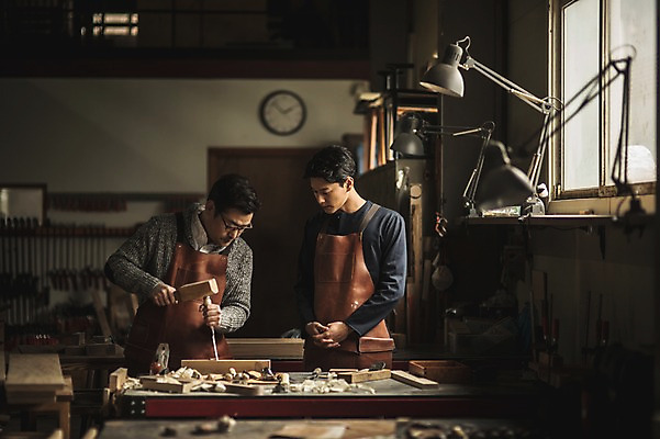 포토 JPG 주간 응시 남자 시계 40대 창문 전등 실내 서기 사람 상반신 20대 성인 두명 목재 앞모습 앞치마 한국인 도구 작업 작업실 목공예 실습 장인 신입 연장세트 작업대 톱밥 합판 성인남자만 국내포토 자연요소 나무 시선 뷰포인트 중년 재료 모션 조명 동양인 청년 내부 공구 가루 공예 남자만 성인만 파일형식