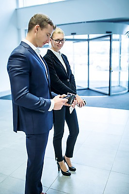 포토 JPG 전신 서양인 응시 여자 남자 커피 비즈니스 실내 서기 미소 들기 사람 정장 성인 두명 옆모습 30대 스마트폰 회전문 성인만 국내포토 외국인 시선 옷 음료 뷰포인트 모션 표정 내부 장년 핸드폰 스마트기기 문 파일형식