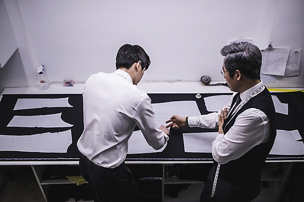 포토 JPG 응시 남자 40대 중년 실내 줄자 설명 서기 사람 정장 상반신 20대 두명 옆모습 뒷모습 한국인 가리킴 직물 작업 가르침 패션디자이너 책상 제자 실습 장인 재단 신입 작업대 남자만 국내포토 시선 옷 교육 뷰포인트 가구 모션 자 동양인 손짓 청년 성인 내부 디자이너 파일형식