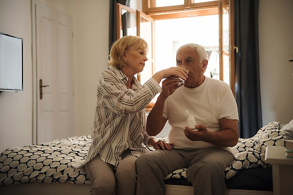 포토 JPG 주간 서양인 응시 여자 노년 남자 창문 탁자 실내 사람 앉기 상반신 두명 앞모습 실버라이프 노부부 침실 침대 약병 먹여주기 물컵 70대 물마시기 국내포토 자연요소 외국인 라이프스타일 부부 시선 뷰포인트 가구 모션 성인 내부 컵 약 마시기 먹기 병_담는 파일형식