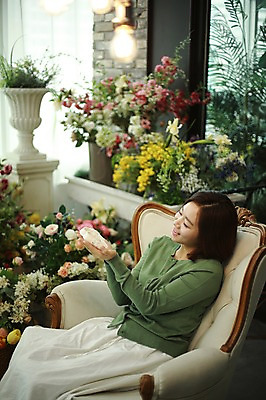 포토 JPG 여자 꽃 화분 실내 한명 미소 들기 사람 앉기 상반신 20대 성인 옆모습 소파 임신 기쁨 한국인 아기신발 안도 부부라이프 성인여자한명만 국내포토 식물 1 라이프스타일 감정 뷰포인트 신발 의자 모션 표정 동양인 청년 내부 아기용품 여자한명만 성인여자만 파일형식