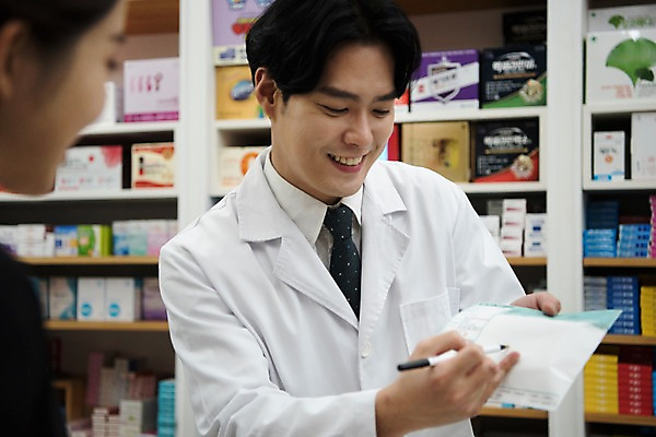 포토 JPG 직업 응시 여자 남자 친절 안내 실내 설명 미소 사람 상반신 20대 성인 두명 앞모습 옆모습 펜 한국인 가리킴 의사가운 약국 고객 조제 약봉투 약사 성인만 국내포토 시선 뷰포인트 의학 모션 봉투 표정 동양인 손짓 청년 내부 필기구 약 의사 가운 만들기 파일형식