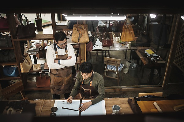 포토 JPG 직업 응시 남자 40대 중년 실내 설명 서기 사람 앉기 상반신 20대 성인 두명 앞모습 하이앵글 팔짱 한국인 작업 가르침 작업실 제조 가죽 집중 스승 제자 실습 장인 가죽공예 제도기구 남자만 가죽공방 국내포토 시선 교육 뷰포인트 컨셉 모션 동양인 청년 내부 기구 공예 파일형식