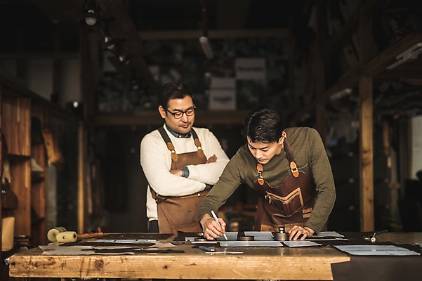 포토 JPG 직업 응시 남자 40대 중년 실내 사람 상반신 20대 성인 두명 앞모습 팔짱 한국인 작업 가르침 작업실 제조 집중 책상 스승 제자 실습 장인 가죽공예 남자만 가죽공방 국내포토 시선 교육 뷰포인트 가구 컨셉 모션 동양인 청년 내부 공예 파일형식