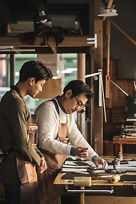 포토 JPG 직업 응시 남자 40대 중년 실내 서기 사람 상반신 20대 성인 두명 옆모습 한국인 작업 작업실 가죽 집중 스승 제자 실습 장인 가죽공예 남자만 가죽공방 국내포토 시선 뷰포인트 컨셉 모션 동양인 청년 내부 공예 파일형식