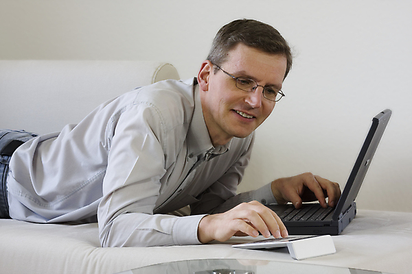 포토 JPG 해외이미지 중년 거실 인터넷 주택 한명 미소 내부 노트북 컴퓨터 소파 계산기 타이핑 업무 작업 계산 무선전화기 타입 해외포토 1 의자 문구용품 표정 사람 성인 건물 전자제품 장비 전화기 파일형식 이미지허브