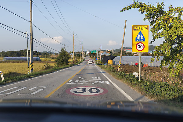 포토 JPG 주간 도로 자동차 하늘 풍경 사람없음 야외 드라이브 운전 도로표지판 안전운전 차안 시골길 보호구역 국내포토 자연요소 길 육상교통 교통시설 모션 표지판 교통안전 구역 파일형식