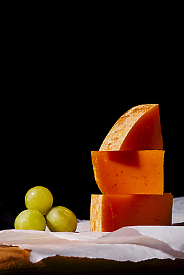 포토 JPG 스튜디오촬영 음식 식재료 검은배경 치즈 실내 사람없음 쌓기 청포도 기름종이 나무도마 조각치즈 국내포토 종이 조각 백그라운드 모션 포도 유제품 도마 내부 목재 검은색 파일형식