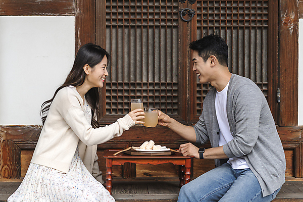 포토 JPG 주간 커플 여자 남자 여행 휴가 휴식 한옥 미소 상반신 20대 성인 야외 두명 옆모습 마주보기 한국인 시골 한과 마주앉기 소반 식혜 다과상 툇마루 성인만 할매니얼 국내포토 여주시 자연요소 한국전통 음료 뷰포인트 컨셉 고건축 관계 모션 탁자 디저트 표정 사람 앉기 동양인 청년 전통음식 마루_인테리어 전통차 신조어 경기도 다과 파일형식