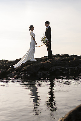 포토 JPG 주간 전신 여자 남자 바다 부케 웨딩드레스 결혼 사랑 서기 미소 들기 정장 턱시도 20대 성인 해변 야외 두명 옆모습 30대 제주도 마주보기 한국인 바위 신랑신부 성인만 웨딩촬영 국내포토 자연요소 드레스 옷 감정 신부_웨딩 뷰포인트 꽃다발 신랑 모션 한국 표정 사람 동양인 이벤트 청년 장년 돌_바위 기념사진 파일형식