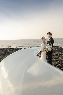 포토 JPG 주간 전신 응시 여자 남자 바다 부케 웨딩드레스 결혼 하늘 날리기 면사포 사랑 서기 미소 들기 정장 턱시도 20대 성인 해변 야외 두명 옆모습 30대 제주도 한국인 바위 신랑신부 성인만 수평선 웨딩촬영 국내포토 자연요소 시선 드레스 옷 감정 신부_웨딩 뷰포인트 꽃다발 신랑 모션 한국 표정 사람 동양인 이벤트 청년 장년 돌_바위 결혼소품 기념사진 파일형식