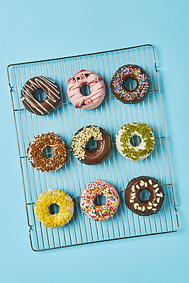 포토 JPG 스튜디오촬영 디저트 실내 종류 그림자 사람없음 하이앵글 여러개 도넛 달콤 파란배경 일렬 토핑 스프링클 식힘망 국내포토 음식 뷰포인트 다수 백그라운드 내부 장식 파란색 주방도구 맛 제빵도구 파일형식