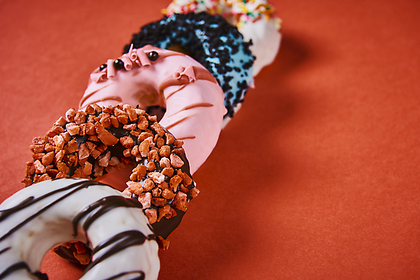 포토 JPG 스튜디오촬영 디저트 실내 종류 그림자 사람없음 여러개 도넛 달콤 일렬 토핑 빨간배경 스프링클 국내포토 음식 다수 백그라운드 내부 장식 빨간색 맛 파일형식