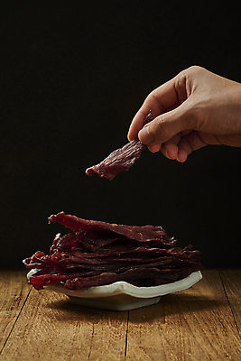 포토 JPG 스튜디오촬영 접시 손 검은배경 실내 들기 신체부위 쌓기 소고기 가공식품 안주 마른안주 육포 국내포토 식기 백그라운드 모션 육류 사람 내부 검은색 파일형식