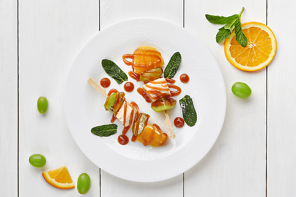 포토 JPG 해외이미지 접시 조각 잎 오렌지 포도 바나나 키위 사람없음 하이앵글 원형 꼬치 민트 시럽 나무탁자 캐러멜 해외포토 도형 식물 식기 뷰포인트 과일 탁자 디저트 허브 파일형식 이미지허브