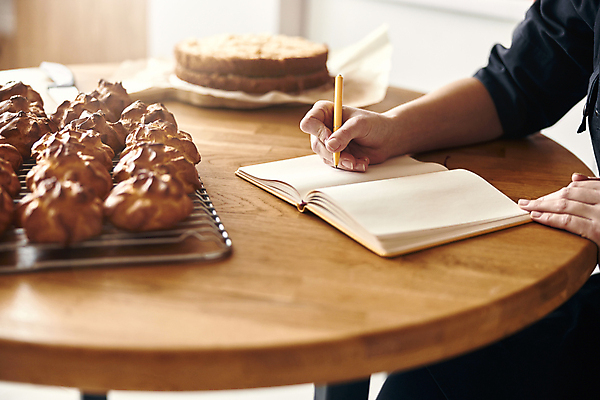 포토 JPG 해외이미지 손 빵 실내 신체부위 펜 다이어리 공책 기록 제빵 나무탁자 식힘망 해외포토 음식 탁자 문구용품 사람 내부 필기구 제과제빵 사무용품 주방도구 제빵도구 파일형식 이미지허브
