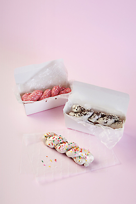 포토 JPG 스튜디오촬영 포장 디저트 실내 사람없음 장식 종이상자 담기 꽈배기 꽈배기빵 음식데코레이션 초코맛 화이트초콜릿 스프링클 분홍색배경 종이호일 국내포토 음식 빵 분홍색 백그라운드 모션 내부 상자 초콜릿 맛 파일형식
