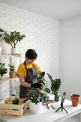 포토 JPG 해외이미지 여자 화분 한명 들기 상반신 성인 옆모습 스마트폰 나무상자 책상 진열장 원예 원예식물 삼각대 원예용품 플로리스트 성인여자한명만 안경낌 인터넷방송 1인미디어 홈가드닝 해외202309 해외포토 식물 직업 1 안경 뷰포인트 가구 생활용품 모션 사람 취미 핸드폰 스마트기기 상자 방송 여자한명만 성인여자만 파일형식