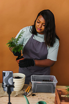 포토 JPG 해외이미지 여자 화분 흑인 한명 들기 상반신 성인 앞모습 스마트폰 책상 원예 원예식물 삼각대 원예용품 플로리스트 성인여자한명만 인터넷방송 1인미디어 홈가드닝 해외202309 해외포토 서양인 식물 직업 1 뷰포인트 가구 생활용품 모션 사람 취미 핸드폰 스마트기기 방송 여자한명만 성인여자만 파일형식