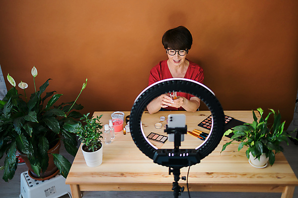 포토 해외이미지 여자 중년 전등 실내 한명 상반신 앞모습 스마트폰 화장 화장용품 방송 화장대 과정 리뷰 소셜네트워크 중년여자한명만 크리에이터 뷰티크리에이터 1인미디어 영상촬영 해외202309 해외포토 직업 1 뷰포인트 가구 컨셉 조명 사람 성인 내부 핸드폰 스마트기기 뷰티 촬영 미용용품 여자한명만 중년여자만 파일형식