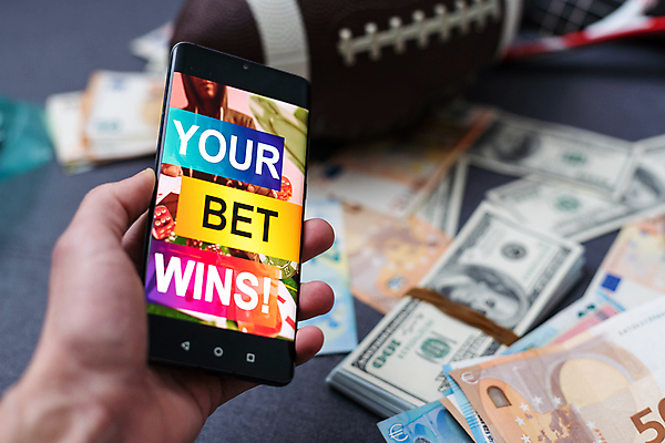 포토 JPG 해외이미지 손 돈 들기 신체부위 스마트폰 도박 어플리케이션 럭비공 해외202309 해외포토 공 모션 사람 핸드폰 스마트기기 재산 럭비용품 파일형식