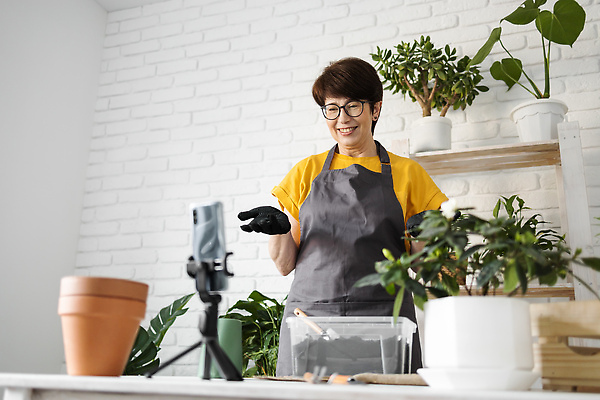 포토 JPG 해외이미지 여자 화분 한명 손짓 상반신 성인 앞모습 스마트폰 나무상자 책상 진열장 원예 원예식물 삼각대 원예용품 플로리스트 성인여자한명만 안경낌 인터넷방송 1인미디어 홈가드닝 해외202309 해외포토 식물 직업 1 안경 뷰포인트 가구 생활용품 모션 사람 취미 핸드폰 스마트기기 상자 방송 여자한명만 성인여자만 파일형식