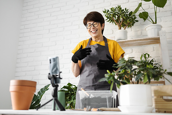 포토 JPG 해외이미지 여자 화분 한명 손짓 상반신 성인 앞모습 스마트폰 나무상자 책상 진열장 원예 원예식물 삼각대 원예용품 플로리스트 성인여자한명만 안경낌 인터넷방송 1인미디어 홈가드닝 해외202309 해외포토 식물 직업 1 안경 뷰포인트 가구 생활용품 모션 사람 취미 핸드폰 스마트기기 상자 방송 여자한명만 성인여자만 파일형식