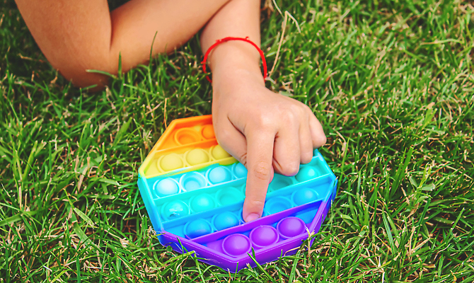 포토 JPG 해외이미지 손 어린이 휴식 잔디 신체부위 장난감 누름 즐거움 무지개색 푸시팝 해외포토 식물 감정 컨셉 모션 사람 컬러풀 파일형식