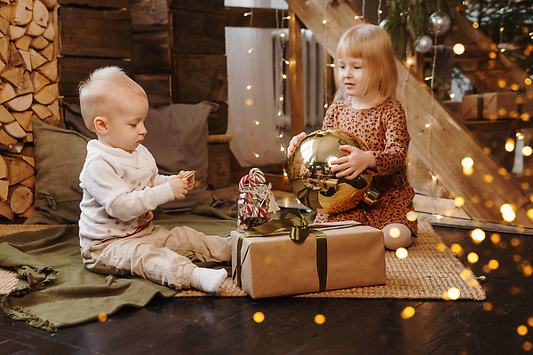 포토 JPG 해외이미지 전신 여자 남자 어린이 크리스마스 실내 남매 크리스마스선물 들기 앉기 손짓 소년 두명 옆모습 선물상자 빛 카펫 알전구 크리스마스이브 홀리데이 어린이만 해외202309 해외포토 기념일 뷰포인트 전구 가족 모션 휴가 선물 사람 내부 상자 파일형식
