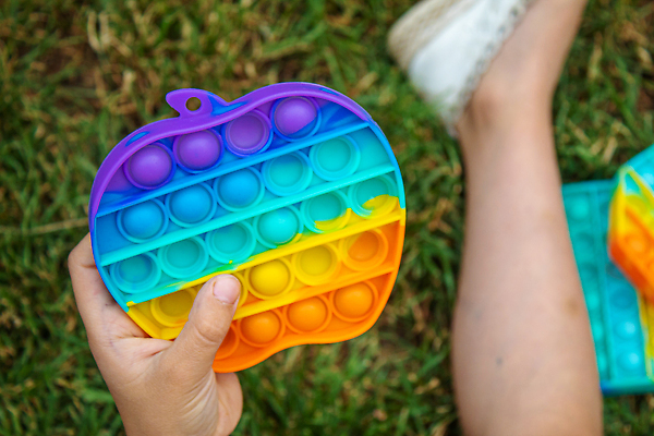 포토 JPG 해외이미지 손 어린이 휴식 잔디 신체부위 장난감 즐거움 무지개색 푸시팝 해외포토 식물 감정 컨셉 사람 컬러풀 파일형식