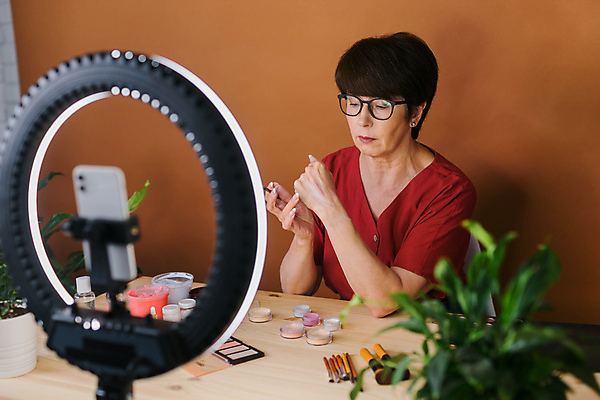 포토 해외이미지 여자 중년 전등 실내 한명 상반신 옆모습 스마트폰 화장 화장용품 방송 화장대 과정 리뷰 소셜네트워크 중년여자한명만 크리에이터 뷰티크리에이터 1인미디어 영상촬영 해외202309 해외포토 직업 1 뷰포인트 가구 컨셉 조명 사람 성인 내부 핸드폰 스마트기기 뷰티 촬영 미용용품 여자한명만 중년여자만 파일형식