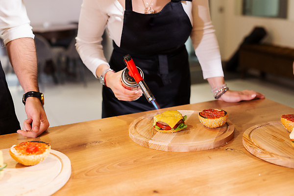 포토 JPG 해외이미지 여자 남자 들기 상반신 성인 두명 앞모습 주방 햄버거 굽기 요리중 요리교실 토치 성인만 해외202309 해외포토 뷰포인트 모션 수업 패스트푸드 요리 사람 공구 구이 파일형식