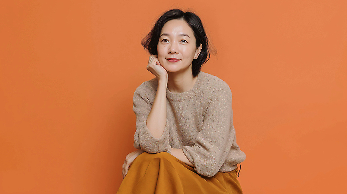 JPG 편집이미지 여자 패션 중년 포즈 백그라운드 생각 표정 미소 앉기 주황색 분위기 편안함 소통 의료성형뷰티 스타일 편집실사 AI인물포토 AI콘텐츠 컬러 컨셉 모션 사람 성인 감각 CG 파일형식 AI포토