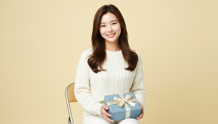 JPG 편집이미지 여자 포장 조명 따뜻함 선물 미소 앉기 파란색 상자 기쁨 축하 생일 편안함 베이지색 의료성형뷰티 편집실사 AI인물포토 AI콘텐츠 기념일 감정 컬러 컨셉 모션 표정 사람 감각 CG 파일형식 AI포토