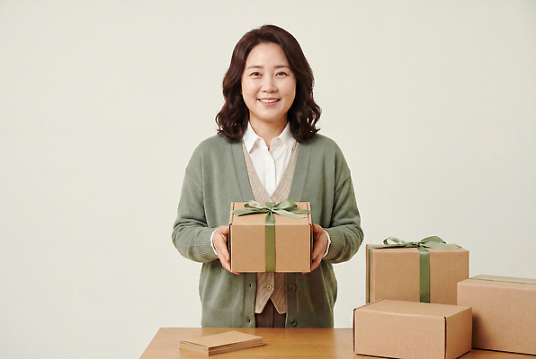 JPG 편집이미지 손 여자 리본 포장 탁자 밝음 선물 미소 상자 포장지 정리 의료성형뷰티 편집실사 AI인물포토 AI콘텐츠 가구 표정 사람 신체부위 CG 파일형식 AI포토 생활용품 오브젝트