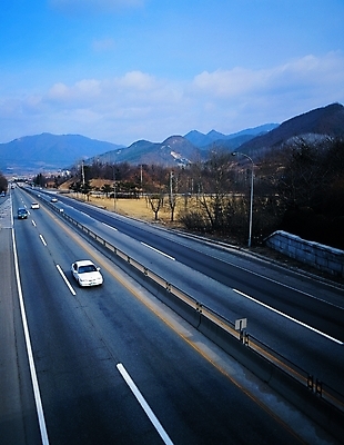 포토 주간 나무 식물 시설물 현대건축 건축 산업 도로 길 육상교통 교통수단 교통 가로등 승용차 자동차 산 사람없음 야외 고속도로 아스팔트 산등성이 주행 현대문화 갓길 현대산업 차선_도로 국내포토 자연요소 건축물 공공시설 문화 교통시설 파일형식