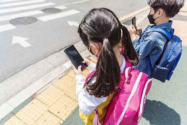포토 JPG 주간 여자 남자 어린이 마스크 서기 안전 근접촬영 상반신 야외 두명 옆모습 스마트폰 한국인 횡단보도 등교 등하교 하교 조심 스마트폰중독 스쿨존 어린이보호구역 어린이만 국내포토 자연요소 뷰포인트 모션 사람 동양인 핸드폰 스마트기기 보행로 중독 보호구역 파일형식