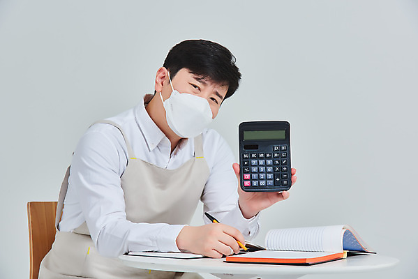 포토 JPG 스튜디오촬영 남자 비즈니스 탁자 회색배경 실내 마스크 한명 앉기 상반신 성인 옆모습 30대 앞치마 한국인 계산기 상인 서비스 고민 자영업 장사 매출 장부 성인남자한명만 소상공인 코로나바이러스 델타변이바이러스 국내포토 직업 1 감정 뷰포인트 가구 백그라운드 모션 문구용품 사람 동양인 내부 장년 경제 장비 회색 바이러스 상업 남자한명만 성인남자만 파일형식