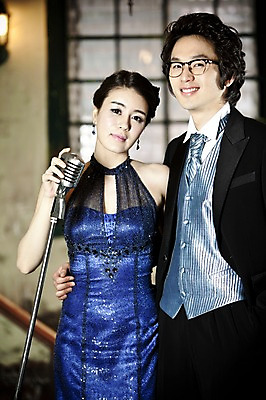 포토 JPG 커플 드레스 옷 원피스 여자 기념일 남자 신부 포즈 신랑 결혼 창문 전등 조명 실내 서기 미소 웃음 사람 동양인 정장 턱시도 손짓 이벤트 상반신 20대 성인 두명 앞모습 한국인 여성복 남성복 마이크 이브닝드레스 신사복 청년만 성인만 국내포토 뷰포인트 음향기기 관계 모션 표정 인종 청년 내부 파일형식