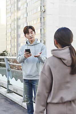 포토 JPG 주간 응시 여자 남자 들기 손짓 상반신 20대 성인 야외 두명 건물 앞모습 뒷모습 30대 스마트폰 한국인 상인 고객 확인 육교 성인만 중고거래 국내포토 자연요소 건축물 시선 뷰포인트 모션 사람 동양인 청년 장년 핸드폰 스마트기기 거래 다리_건축물 파일형식