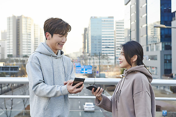 포토 JPG 주간 여자 남자 미소 들기 상반신 20대 성인 야외 두명 건물 옆모습 아웃포커스 30대 스마트폰 마주보기 한국인 상인 고객 확인 육교 성인만 중고거래 국내포토 자연요소 건축물 뷰포인트 모션 촬영기법 표정 사람 동양인 청년 장년 핸드폰 스마트기기 거래 다리_건축물 파일형식