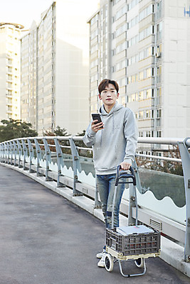 포토 JPG 주간 전신 남자 한명 서기 들기 성인 야외 건물 앞모습 30대 스마트폰 수레 한국인 잡기 기다림 상인 육교 성인남자한명만 중고거래 국내포토 자연요소 1 건축물 뷰포인트 모션 사람 동양인 장년 핸드폰 스마트기기 카트 거래 다리_건축물 남자한명만 성인남자만 파일형식