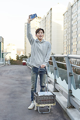 포토 JPG 주간 전신 남자 한명 서기 미소 들기 성인 야외 건물 앞모습 30대 스마트폰 손들기 수레 한국인 상인 육교 성인남자한명만 중고거래 국내포토 자연요소 1 건축물 뷰포인트 모션 표정 사람 동양인 장년 핸드폰 스마트기기 카트 거래 다리_건축물 남자한명만 성인남자만 파일형식