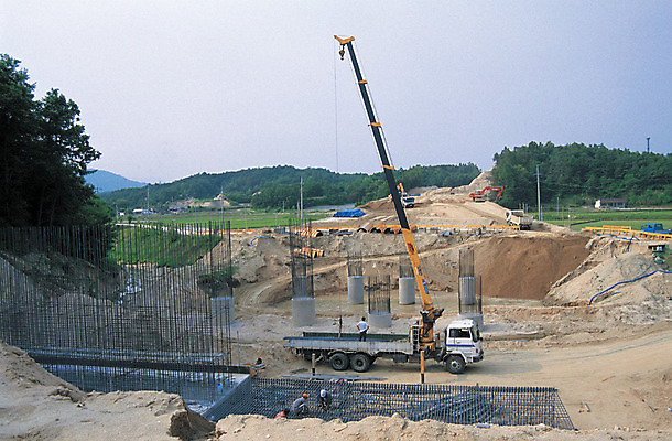 포토 JPG 주간 건축 산업 육상교통 교통수단 한대 공업 자동차 자연 노동자 산 건설업 공사 사람 여러명 야외 경제 흙 건설현장 트럭 작업 작업실 중장비 발전 기중기 철근 뼈대 공사중 기초공사 국내포토 자연요소 직업 1 다수 교통 컨셉 산업장비 생태계 파일형식