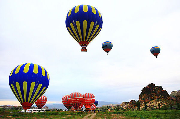 포토 JPG 나무 식물 구름 해외풍경 해외 여행 중동 자동차 자연 하늘 레저 바위산 산 카파도키아 풍경 초원 레포츠 골짜기 암석 돌_바위 바위 열기구 비행 기암괴석 애드벌룬 풍선 튀르키예 국내포토 자연요소 나라 아시아 육상교통 항공교통 바위_돌 돌산 생태계 파일형식